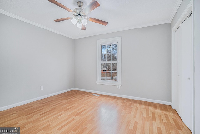 unfurnished bedroom with light wood-type flooring, a closet, ceiling fan, and crown molding