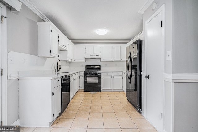 kitchen featuring ornamental molding, a textured ceiling, black appliances, light tile patterned floors, and white cabinets