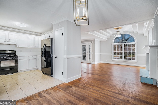 kitchen featuring white cabinets, ceiling fan with notable chandelier, light hardwood / wood-style flooring, and black appliances