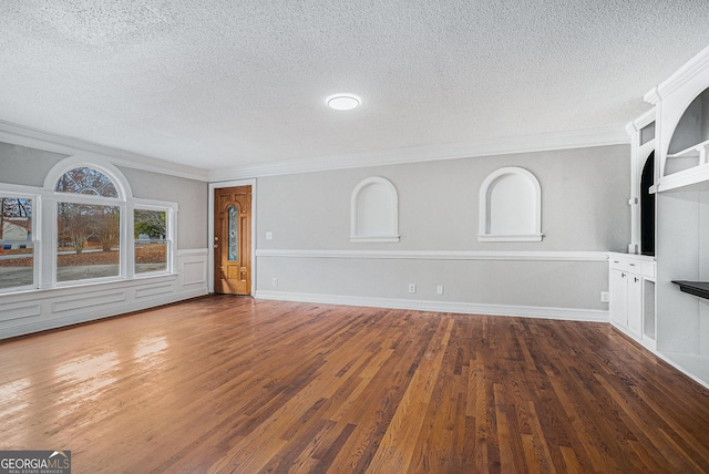 unfurnished living room featuring dark hardwood / wood-style flooring, a textured ceiling, and ornamental molding