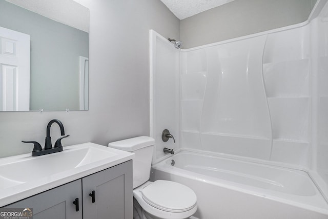 full bathroom with vanity, toilet, washtub / shower combination, and a textured ceiling