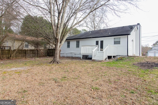 rear view of property with a deck and a lawn