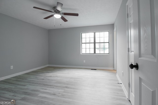 spare room with a textured ceiling, light hardwood / wood-style floors, and ceiling fan