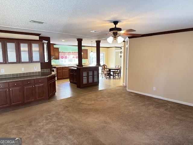 kitchen with carpet, dark brown cabinets, a textured ceiling, and a kitchen island