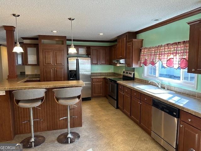 kitchen with a kitchen breakfast bar, sink, a textured ceiling, range hood, and appliances with stainless steel finishes