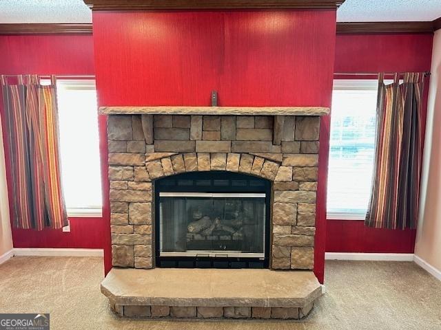 interior details featuring carpet, a stone fireplace, and crown molding