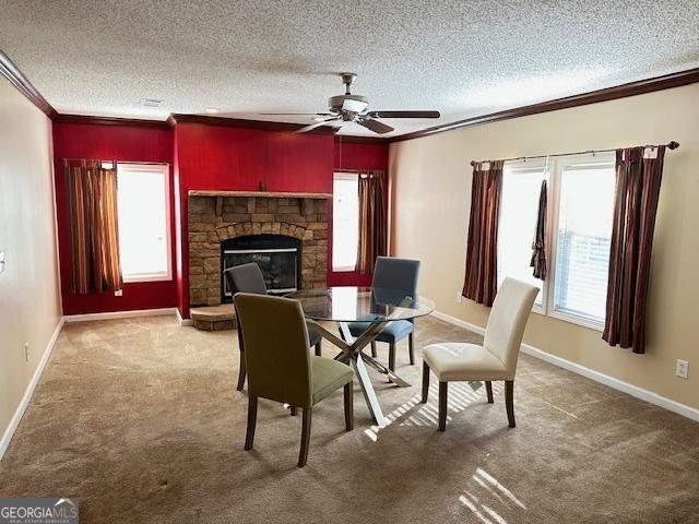 dining room featuring ceiling fan, carpet floors, a textured ceiling, a fireplace, and ornamental molding