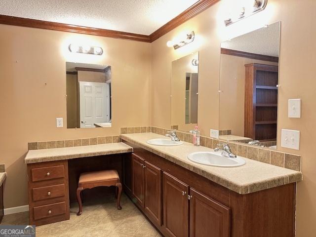 bathroom featuring tile patterned floors, vanity, a textured ceiling, and ornamental molding