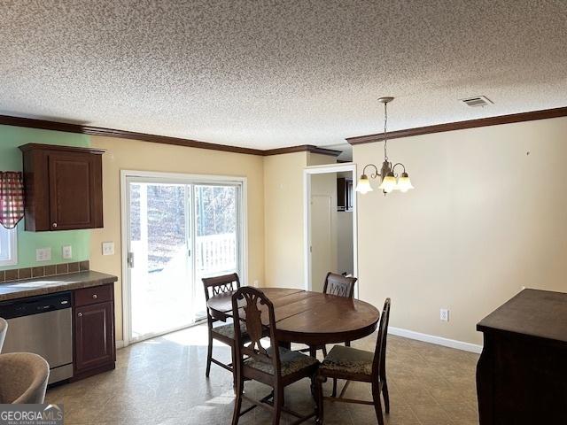 dining room featuring a notable chandelier, ornamental molding, and a textured ceiling