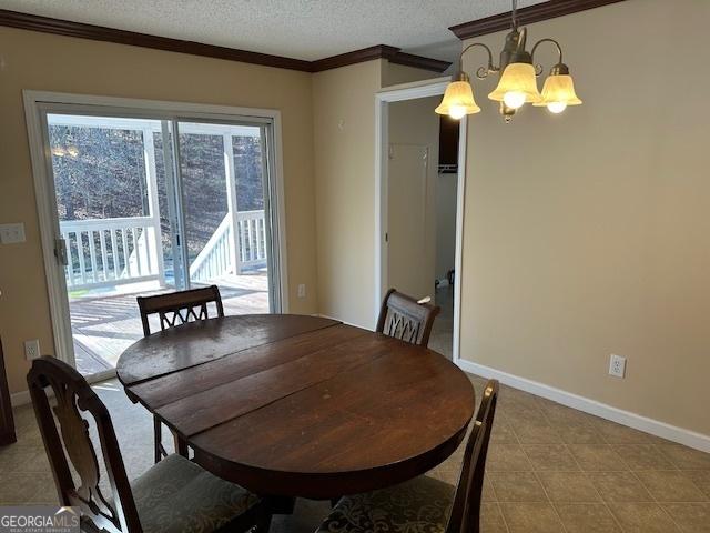 dining room featuring a chandelier, a textured ceiling, and crown molding