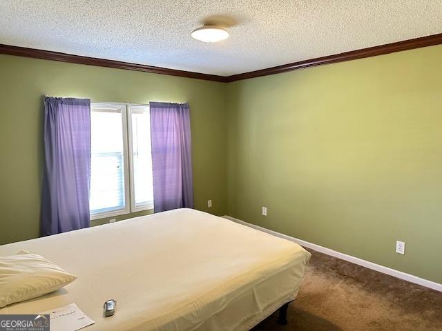 unfurnished bedroom featuring carpet flooring, crown molding, and a textured ceiling