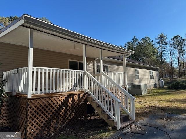 back of house with cooling unit and covered porch