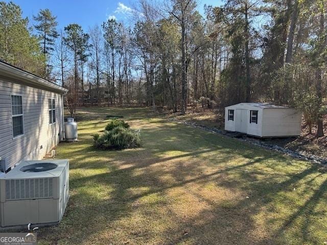 view of yard featuring central AC unit and a storage unit