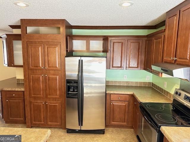 kitchen featuring ornamental molding, a textured ceiling, and appliances with stainless steel finishes