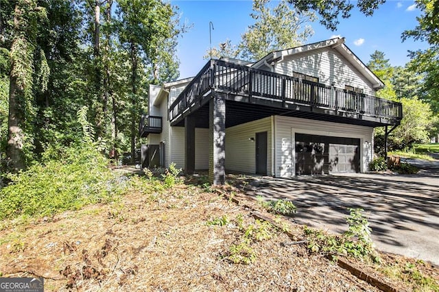 view of property exterior featuring a deck and a garage