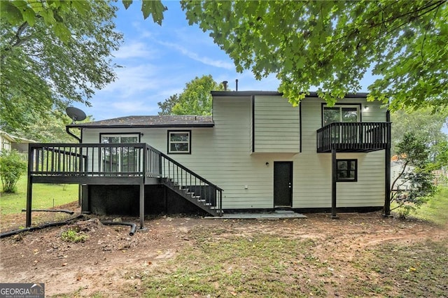 rear view of house featuring a wooden deck