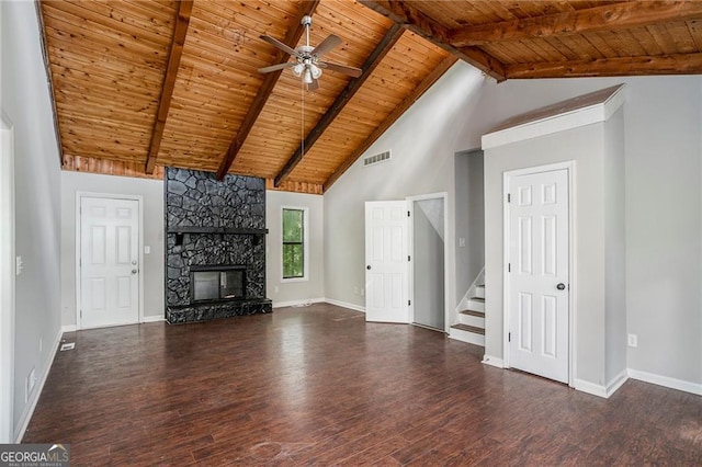 unfurnished living room with beamed ceiling, a stone fireplace, and wooden ceiling