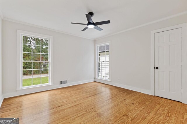 empty room featuring ceiling fan, crown molding, and light wood-type flooring