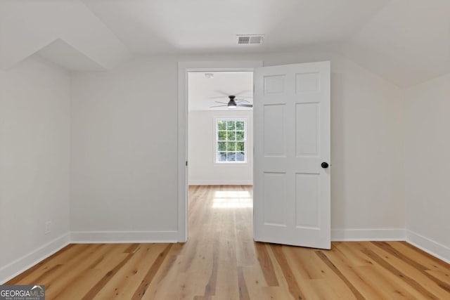 unfurnished bedroom featuring ceiling fan, ensuite bathroom, and light hardwood / wood-style floors