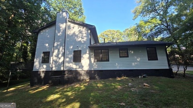 rear view of house featuring a yard