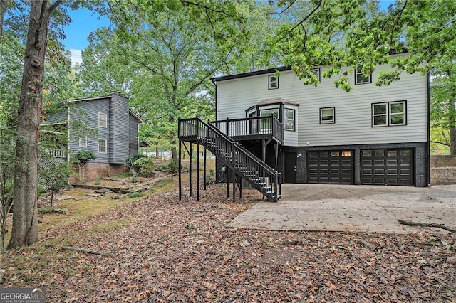 back of house with a garage and a deck