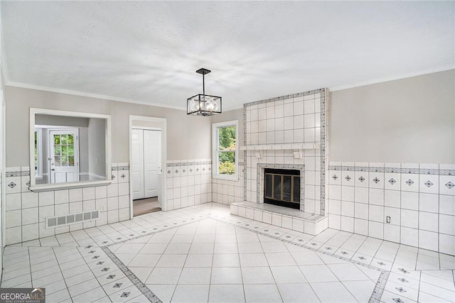 unfurnished living room featuring a tiled fireplace, plenty of natural light, and light tile patterned floors