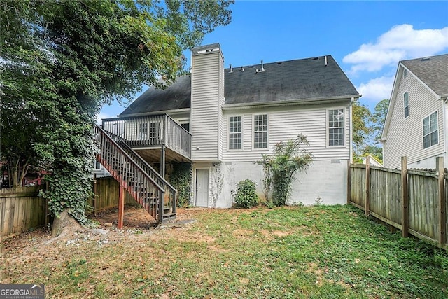 rear view of house featuring a deck and a yard