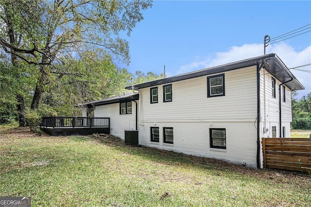 back of property with a lawn, central AC, and a deck