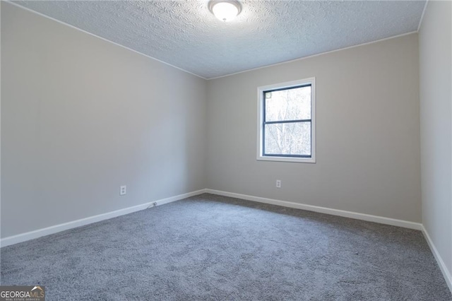 carpeted empty room with a textured ceiling