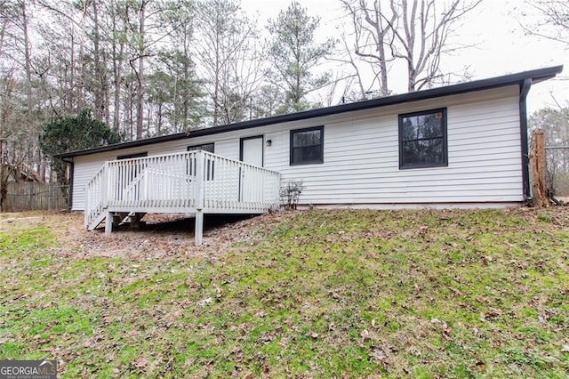 view of front facade with a deck and a front yard