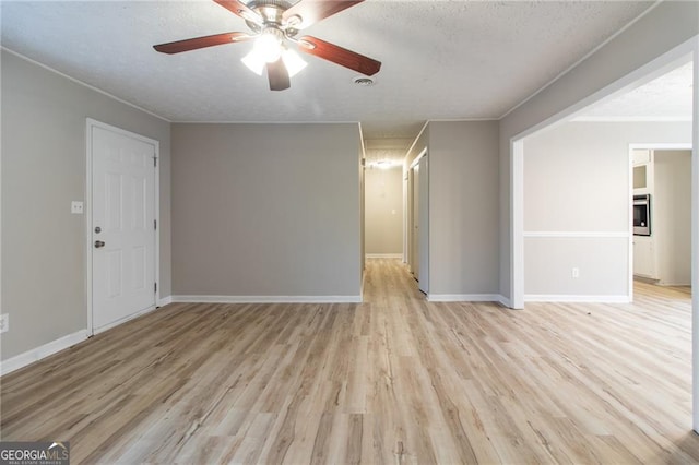 spare room featuring ceiling fan, light hardwood / wood-style floors, and a textured ceiling