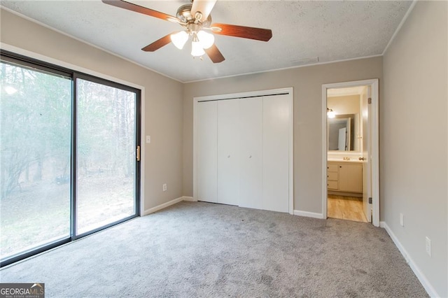 unfurnished bedroom featuring ensuite bath, ceiling fan, a closet, and light colored carpet