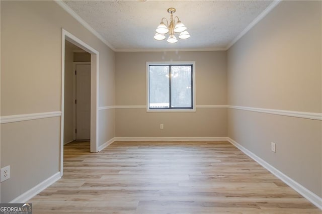 unfurnished dining area featuring crown molding, a chandelier, a textured ceiling, and light wood-type flooring