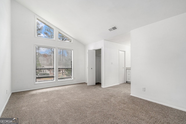 unfurnished bedroom featuring carpet floors and high vaulted ceiling