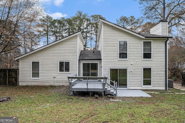 back of property featuring central air condition unit, a wooden deck, a patio area, and a lawn