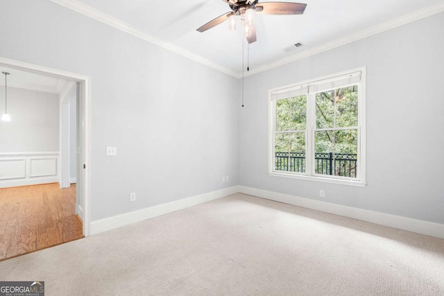 carpeted empty room featuring ceiling fan and ornamental molding