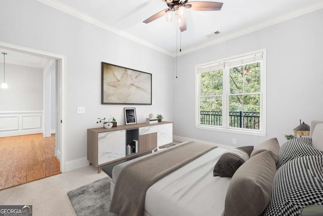 carpeted bedroom with ceiling fan and crown molding