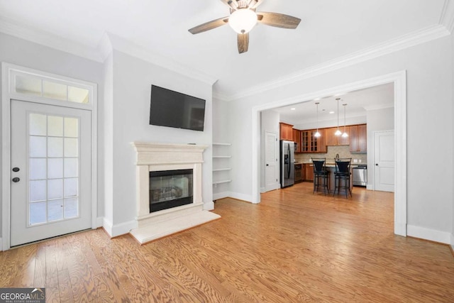 unfurnished living room with crown molding, built in features, ceiling fan, and light hardwood / wood-style floors