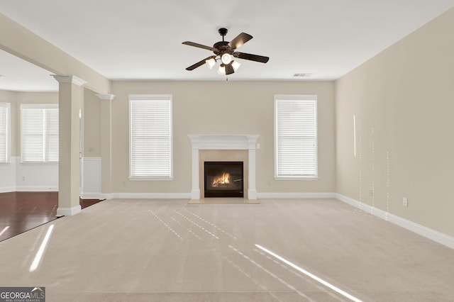 unfurnished living room featuring light carpet, a wealth of natural light, and ceiling fan