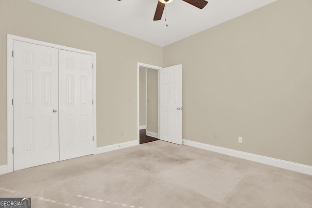 unfurnished bedroom with carpet, a closet, and ceiling fan