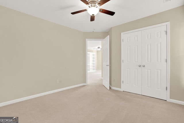 unfurnished bedroom featuring a closet, light colored carpet, and ceiling fan