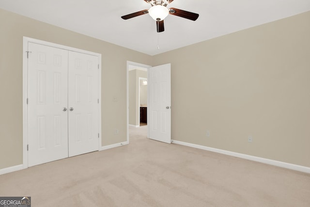 unfurnished bedroom with ceiling fan, light colored carpet, and a closet