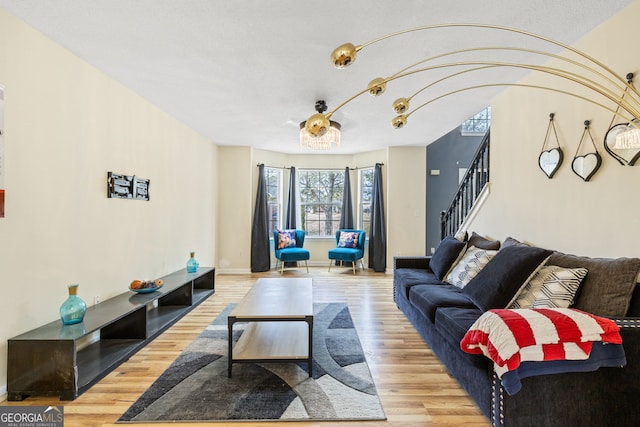 living area featuring stairway, baseboards, and wood finished floors