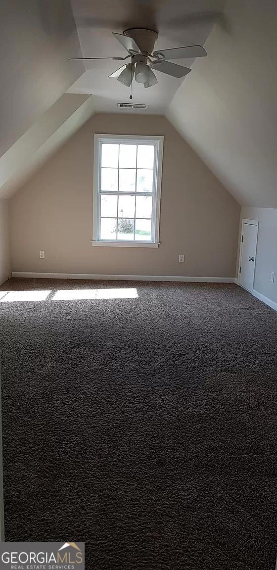 additional living space featuring vaulted ceiling, ceiling fan, and carpet flooring