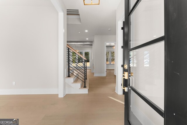 foyer entrance featuring light hardwood / wood-style floors and a notable chandelier