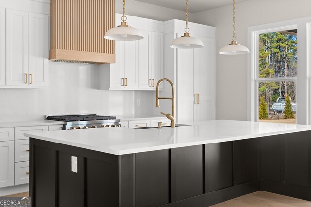 kitchen with decorative backsplash, pendant lighting, a center island, and white cabinetry