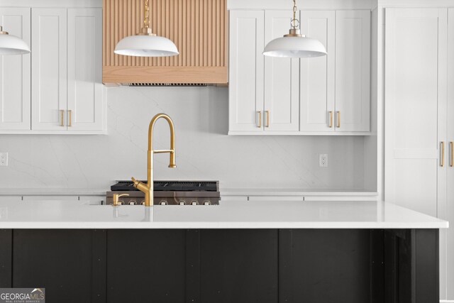 kitchen with sink, white cabinets, and hanging light fixtures