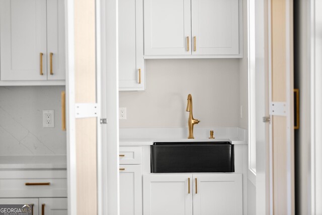 interior space with white cabinets and sink