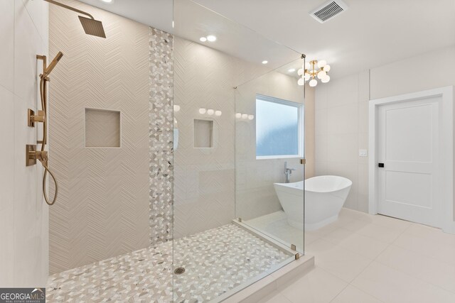 bathroom with plus walk in shower, tile patterned floors, and tile walls