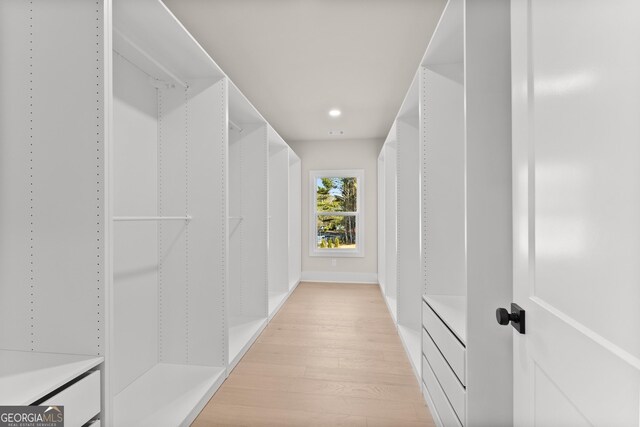 spacious closet with light hardwood / wood-style flooring